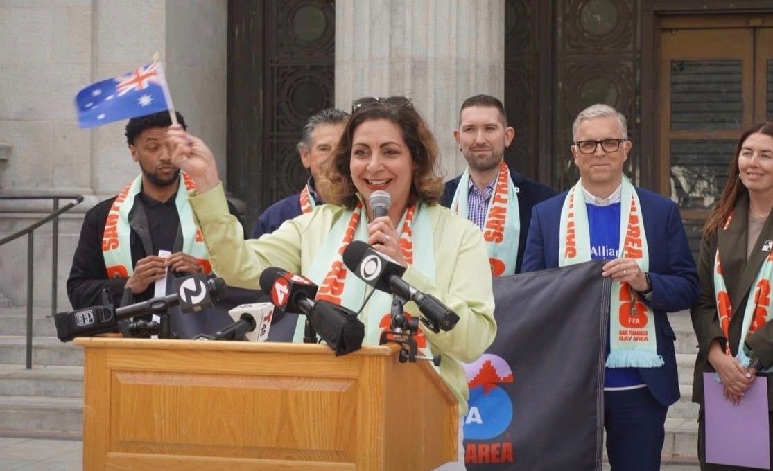 Kim Bardakian waving a flag with Visit Oakland